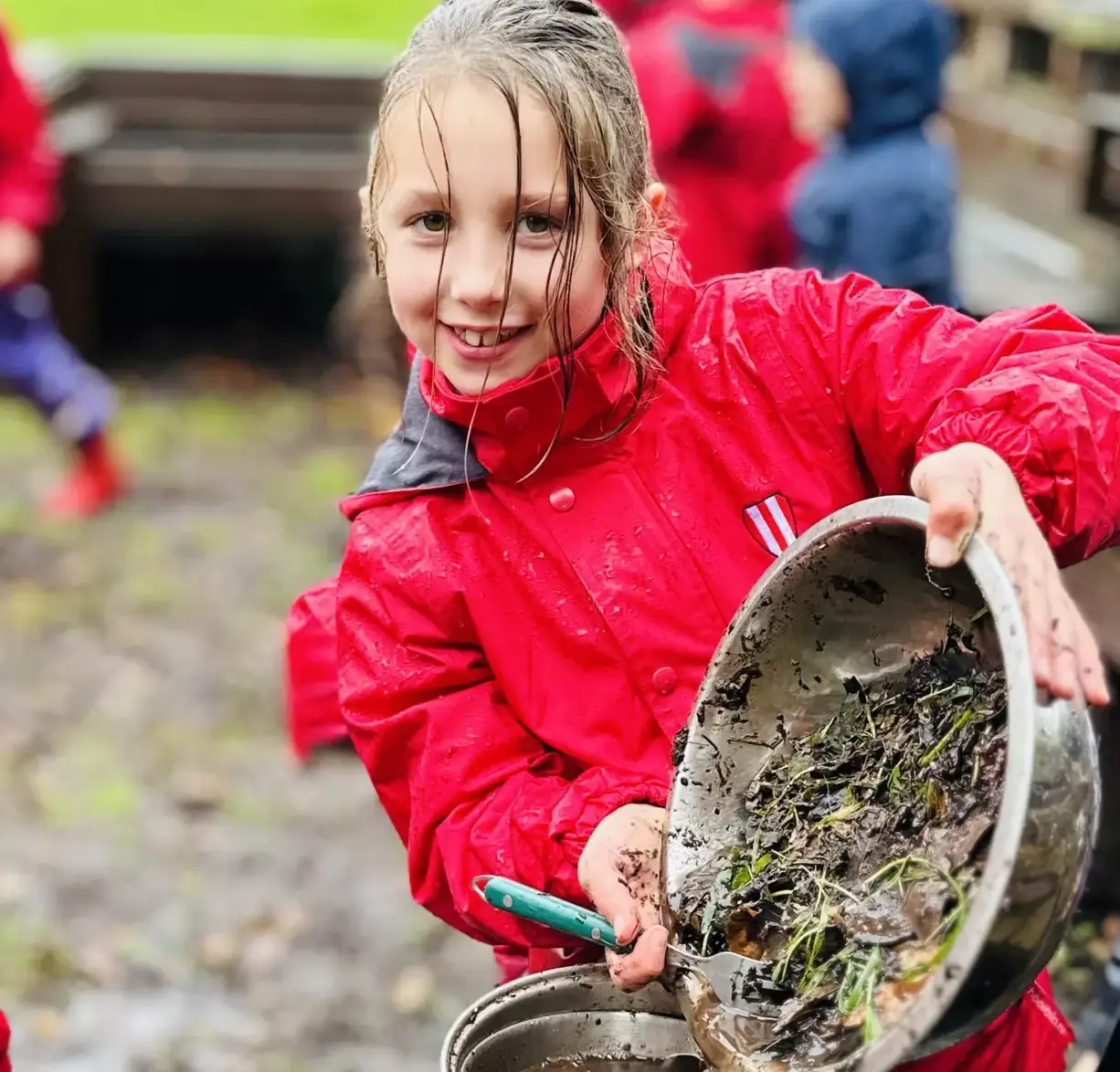 Student showing off bucket full of muck