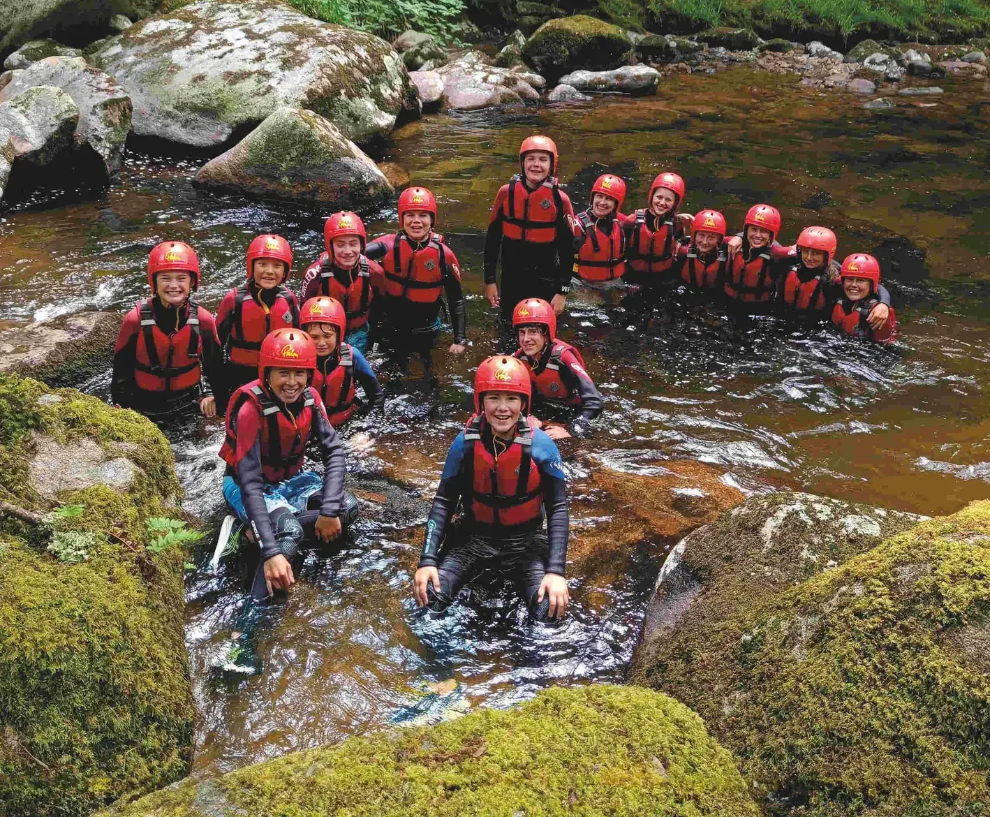 pupils in outdoors gear wearing helmets in the river independent schools near somerset